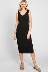 woman wearing a black ribbed sleeveless midi dress with shoulder ties and tan sandals