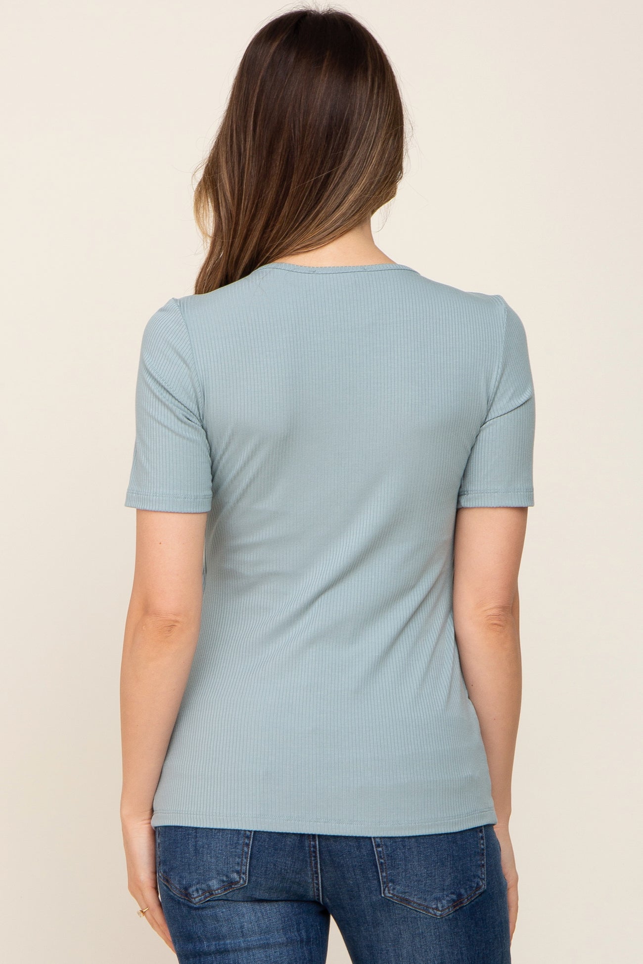 woman wearing a dusty blue ribbed maternity top with short sleeves, seen from the back