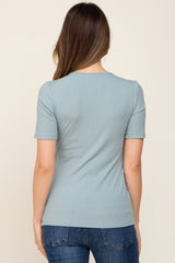 woman wearing a dusty blue ribbed maternity top with short sleeves, seen from the back