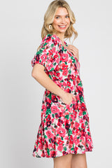 woman wearing a short sleeve pink and red floral tiered mini dress with pockets