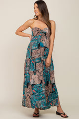woman wearing a strapless maxi maternity dress with a colorful paisley pattern and a tiered design