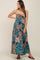woman wearing a strapless maxi maternity dress with a colorful paisley pattern and a tiered design