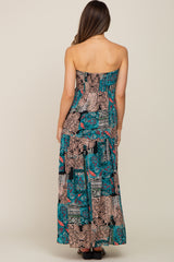 woman wearing a multi-colored strapless maternity maxi dress with a flowy skirt from the back