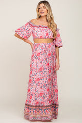 woman wearing pink floral off-the-shoulder crop top and matching maxi skirt set