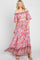 woman wearing a pink floral two-piece maxi dress with off-the-shoulder top and flowing skirt