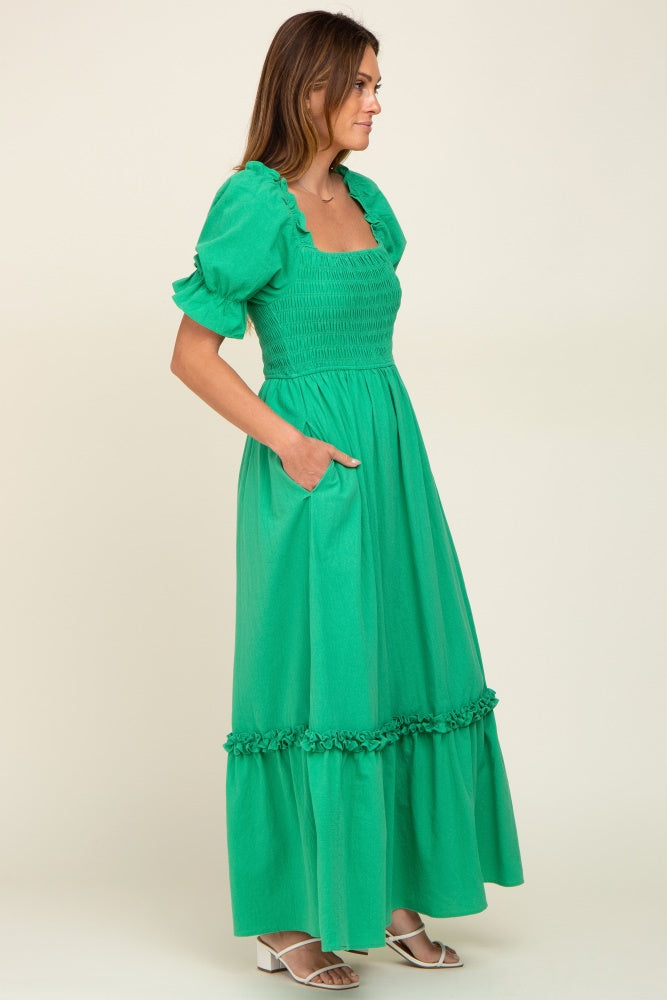 woman wearing a green smocked maxi dress with puff sleeves and pockets