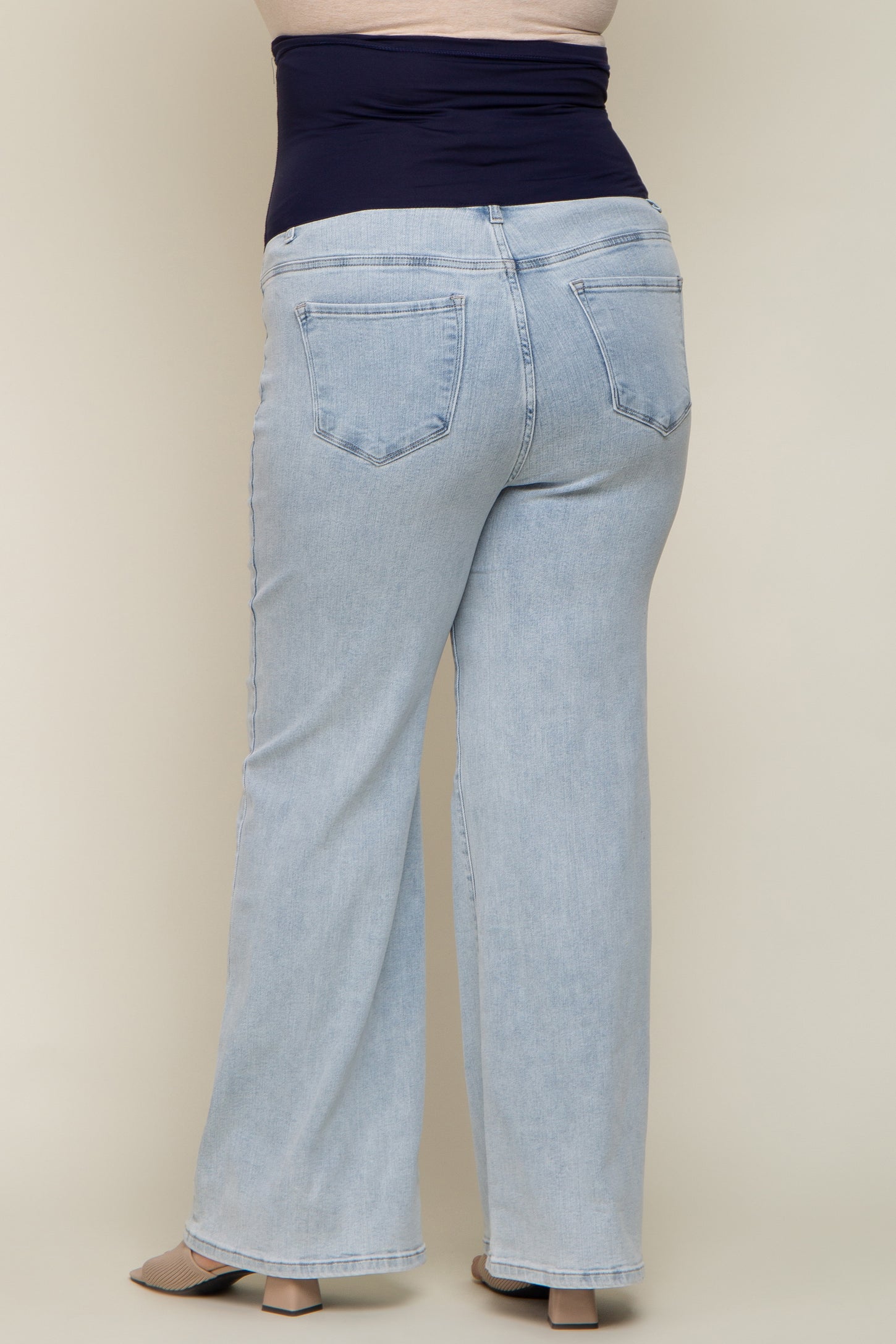 woman wearing light blue maternity plus size jeans with a wide waistband, viewed from the back