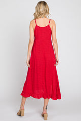 woman wearing a red spaghetti strap midi dress with a flowy hem and a subtle print, showing the back view