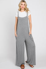 woman wearing a gray wide-leg jumpsuit with pockets over a white t-shirt