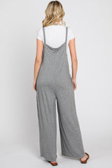 woman wearing a gray sleeveless jumpsuit with wide legs, viewed from the back