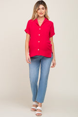 pregnant woman wearing a red short sleeve button down maternity top and light wash jeans