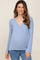 woman wearing a light blue long sleeve wrap maternity top with a visible baby bump