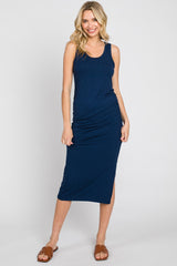 woman wearing a navy blue ribbed tank dress with side ruching and a thigh slit, standing and smiling