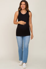 woman wearing a black tank top maternity wear and light blue jeans, holding her baby bump