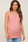 Pregnant woman wearing a pink ribbed maternity tank top and blue jeans