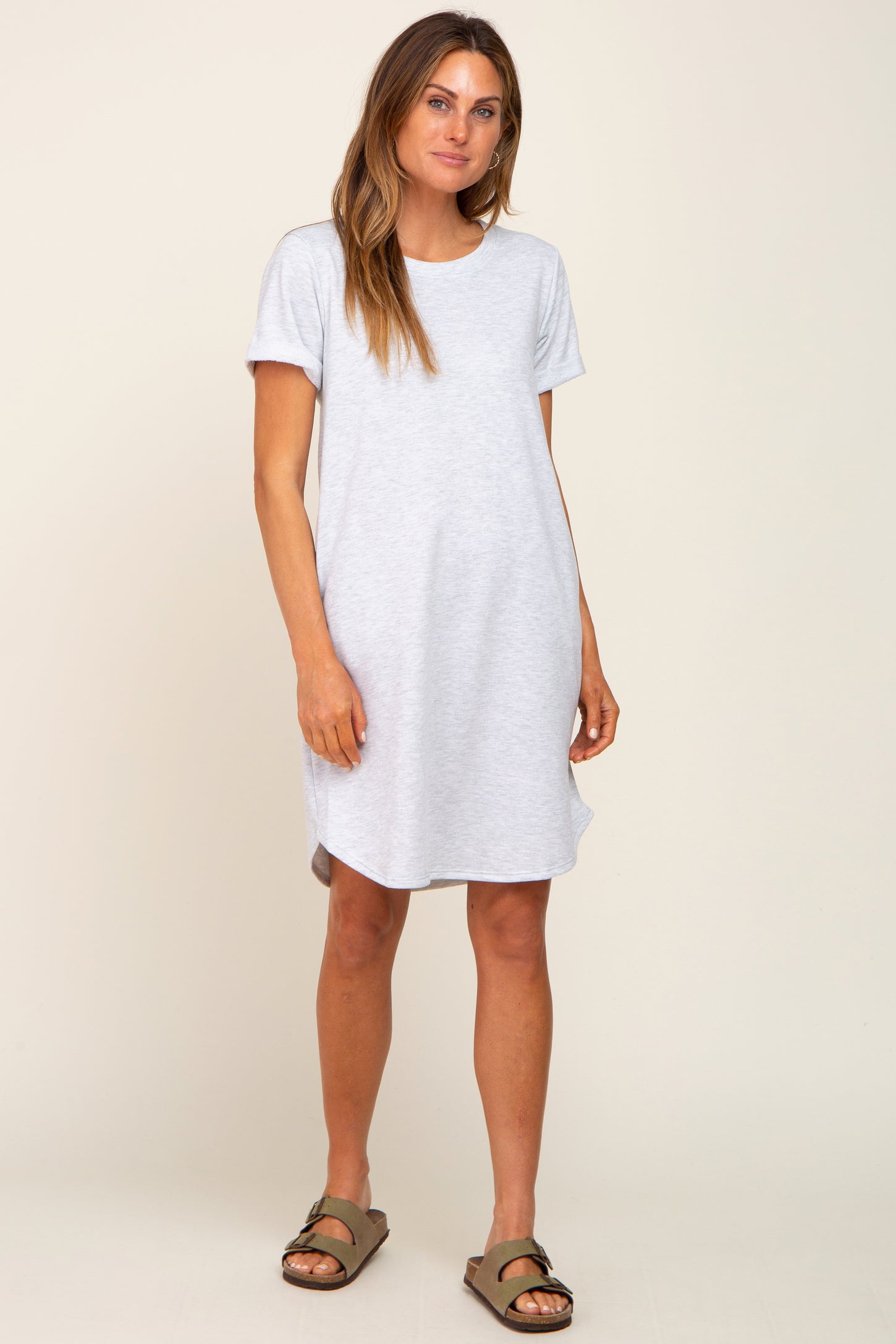 woman wearing a gray short sleeve casual dress with a relaxed fit and side slits, standing in a neutral background