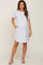 woman wearing a light gray maternity short sleeve dress with pockets and a visible baby bump