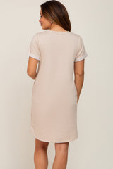 woman wearing a beige maternity dress with short sleeves and a relaxed fit, showing the back view