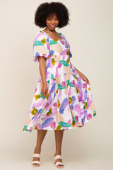 Woman wearing a colorful abstract print tiered midi dress with puff sleeves and a square neckline