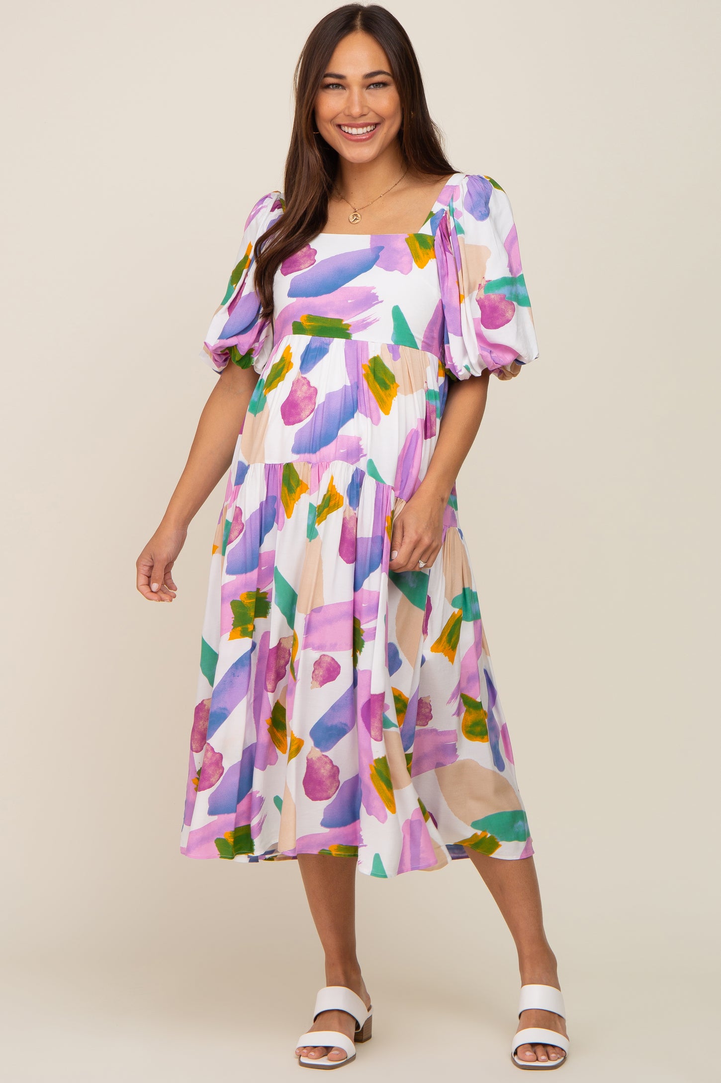 woman wearing a white maternity midi dress with purple and green abstract brushstroke print and puff sleeves