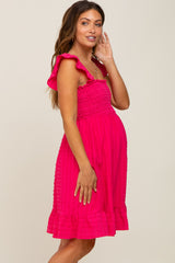 pregnant woman wearing a hot pink smocked maternity dress with ruffle sleeves