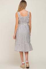 Back view of a woman wearing a blue and white vertical striped sleeveless midi dress with a ruffled hem
