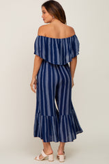 woman wearing a navy blue and white striped off-the-shoulder maternity jumpsuit with ruffled hem