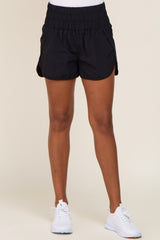 woman wearing black athletic shorts with an elastic waistband and side pockets, paired with white sneakers