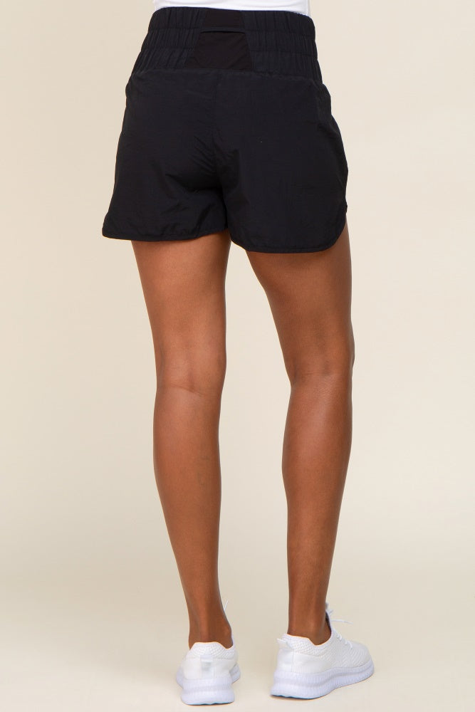 woman wearing black athletic shorts, showing the back view and paired with white sneakers