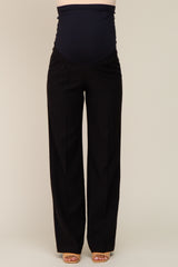 woman wearing black maternity pants with a stretchy waistband over a visible baby bump