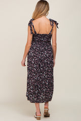woman wearing a black floral maternity maxi dress with tie straps and smocked back, showing her baby bump