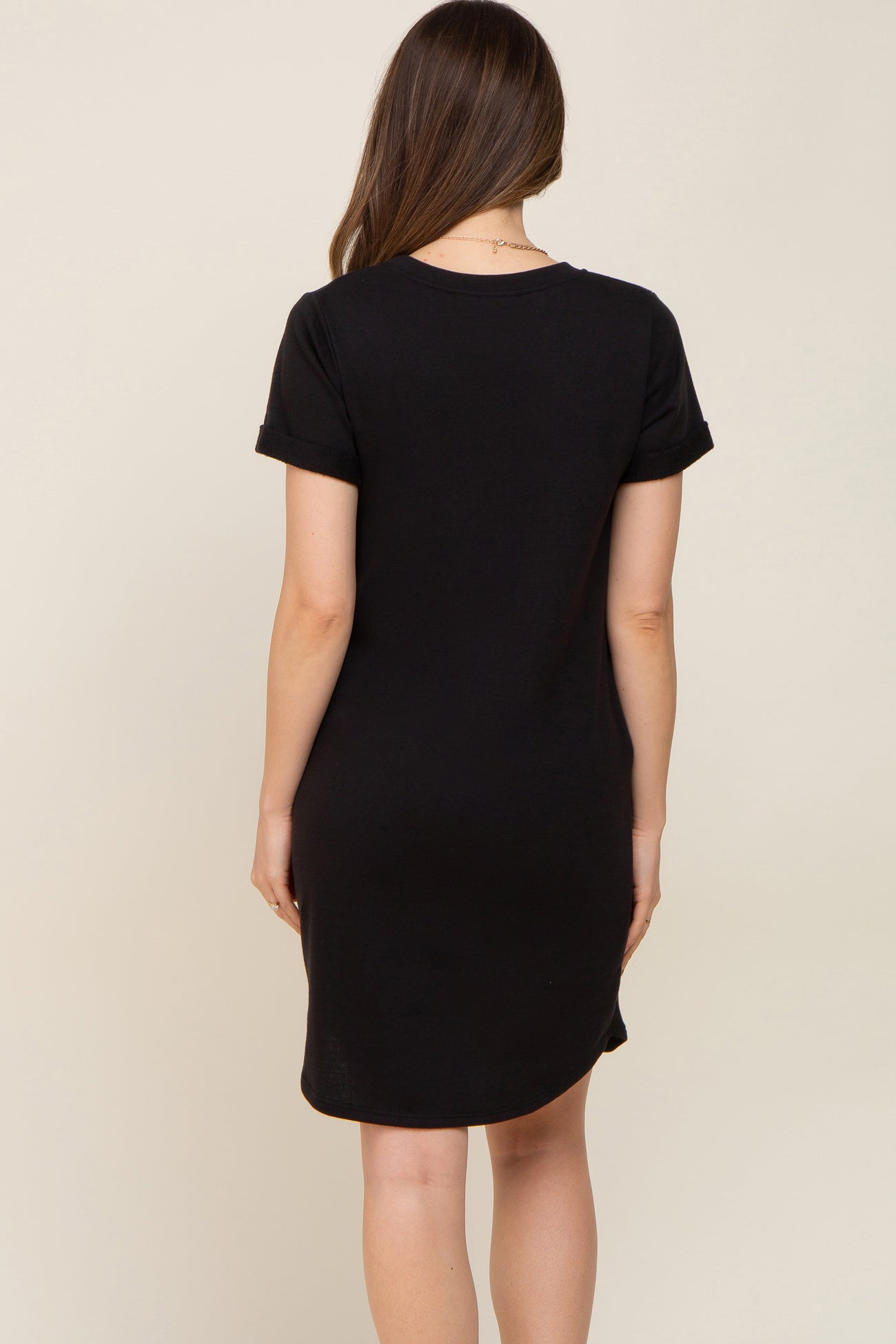 woman wearing a black short sleeve maternity dress, seen from the back