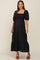 woman wearing a black maternity maxi dress with square neckline and puff sleeves, showcasing her baby bump