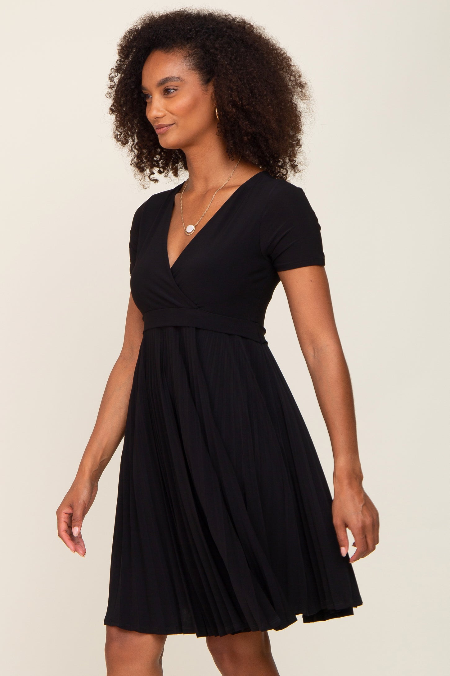 woman wearing a black short sleeve pleated wrap dress
