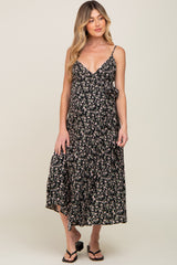 woman wearing a black floral maternity wrap midi dress with spaghetti straps and sandals