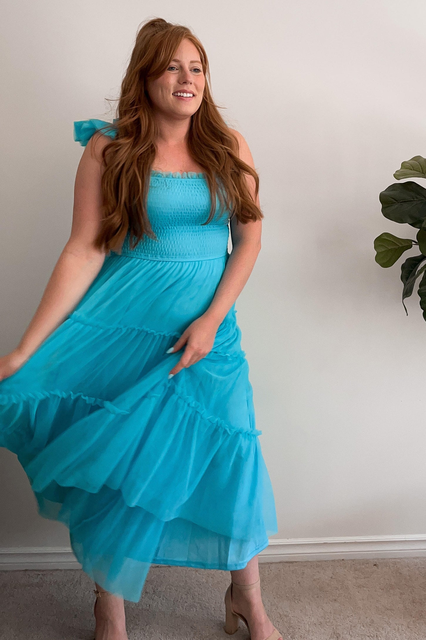 woman wearing a turquoise long maxi dress with ruffled skirt and off-the-shoulder straps
