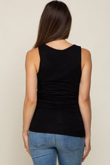 Back view of a woman wearing a black sleeveless maternity tank top and blue jeans