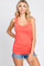 woman wearing a coral pink scoop neck tank top and denim shorts against a white background