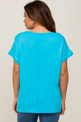 woman wearing a bright turquoise maternity top with short sleeves and a relaxed fit, seen from the back