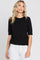 woman wearing a black short sleeve sweater and white jeans