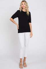 woman wearing a black short sleeve sweater paired with white skinny jeans and heeled sandals