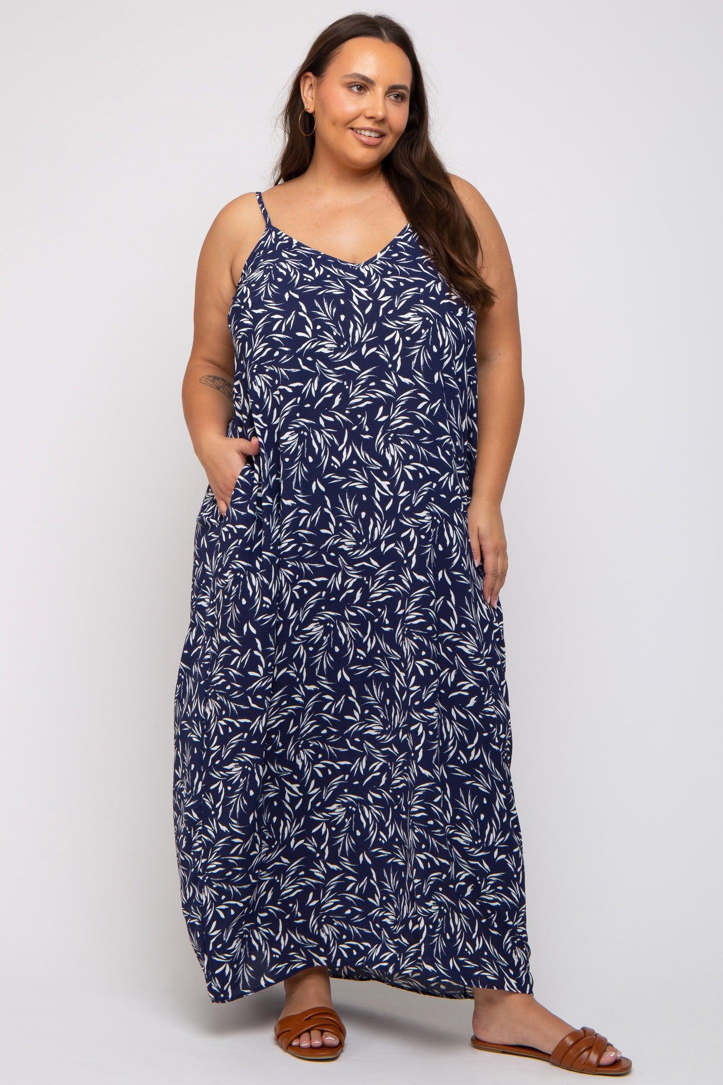 woman wearing a navy blue floral maxi dress with spaghetti straps and pockets