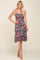 woman wearing a black floral print sundress with spaghetti straps and a smocked bodice