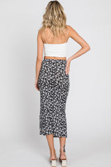 woman from behind wearing a white crop top and a black and white floral midi skirt