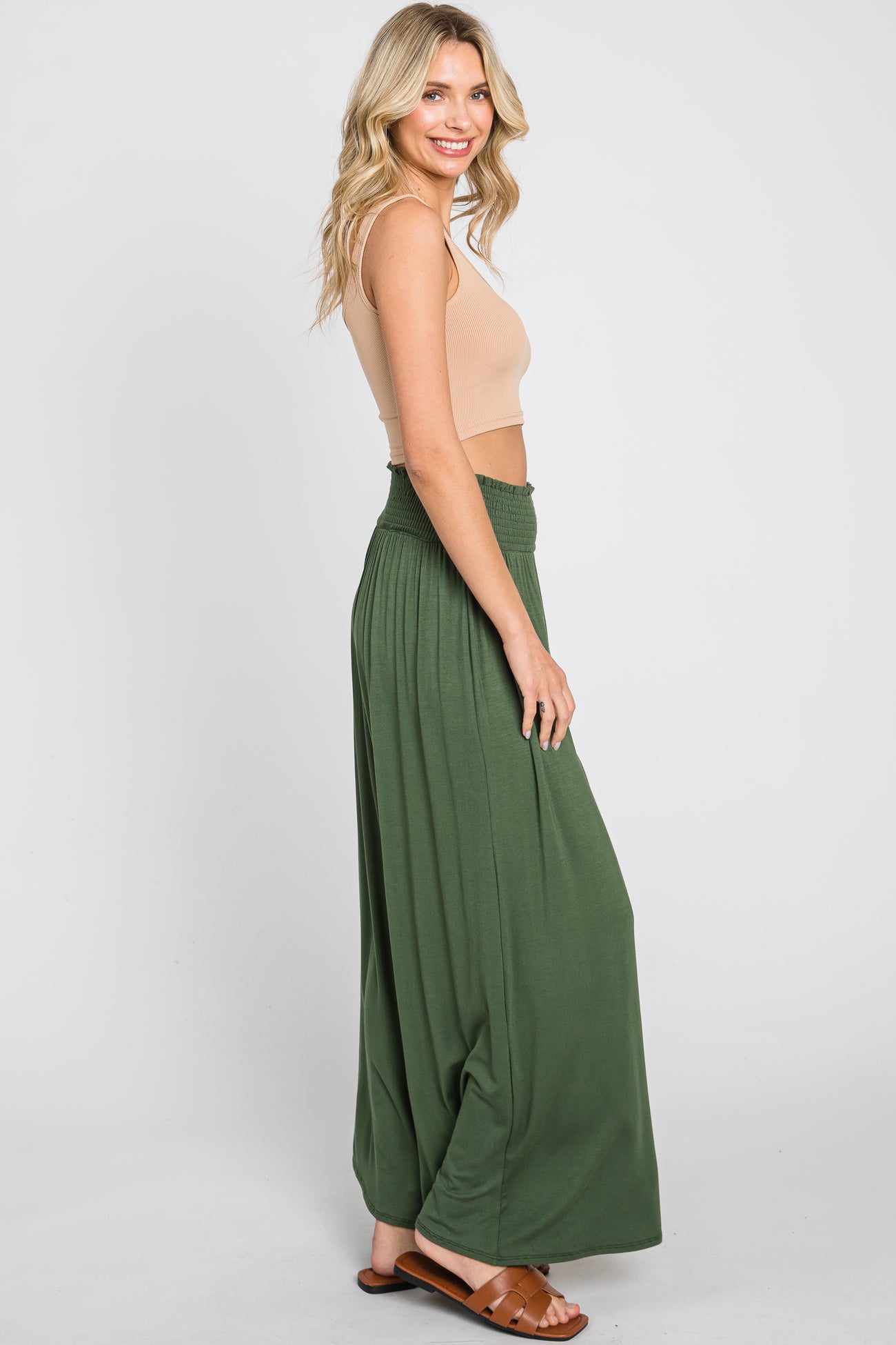 Woman wearing olive green wide leg maxi skirt and tan crop top with brown sandals