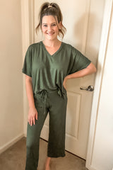 woman wearing a relaxed fit olive green two-piece lounge set with a v-neck and drawstring shorts