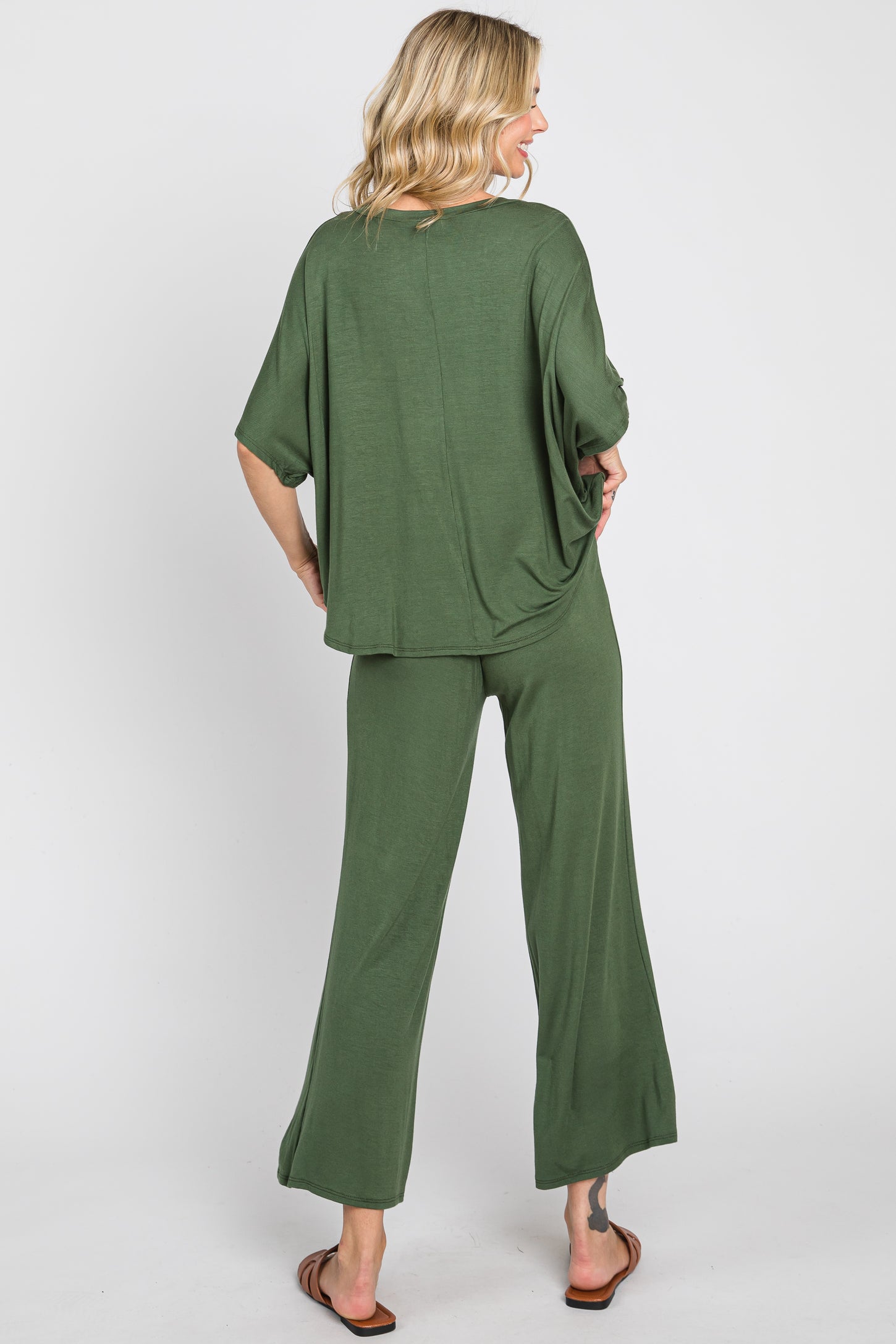 woman wearing a loose fit dark green two-piece lounge set with wide-leg pants and a relaxed top, viewed from the back