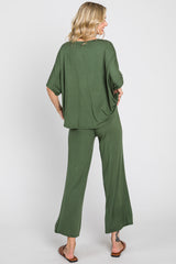 woman wearing a loose fit dark green two-piece lounge set with wide-leg pants and a relaxed top, viewed from the back