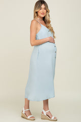 Pregnant woman wearing a light blue button-down maternity midi dress and white wedge sandals