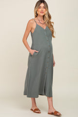Pregnant woman wearing a sage green button-down maternity midi dress with pockets and spaghetti straps